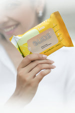Load image into Gallery viewer, Lieve Care lemon facial wipes in a yellow packaging held by a person for refreshing skin care